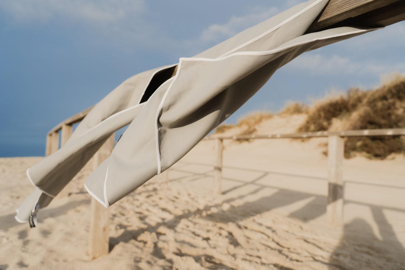 Graues Mikrofaser Handtuch Fitness hängt am Strand